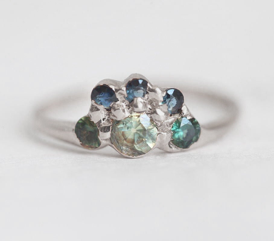 Round teal sapphire ring with green and blue accent sapphires