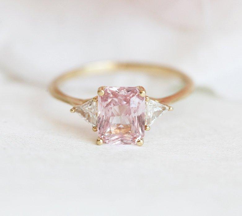 Radiant peach pink sapphire ring with white side diamonds