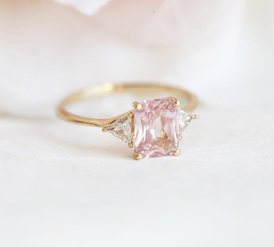 Radiant peach pink sapphire ring with white side diamonds