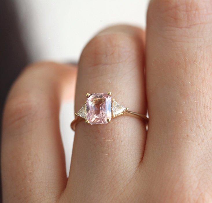 Radiant peach pink sapphire ring with white side diamonds