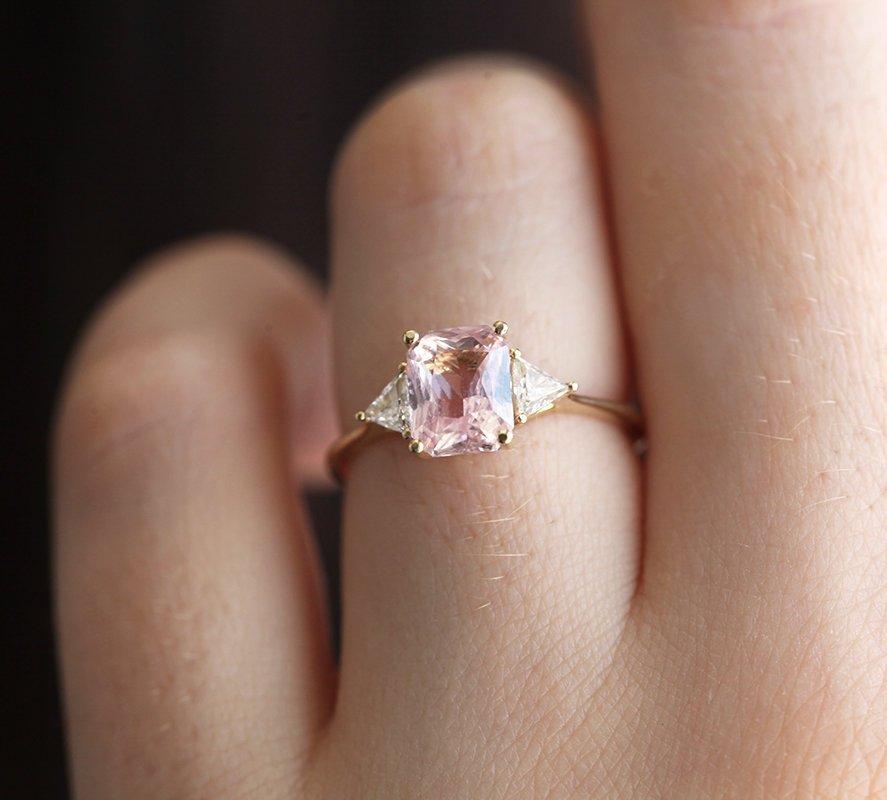 Radiant peach pink sapphire ring with white side diamonds