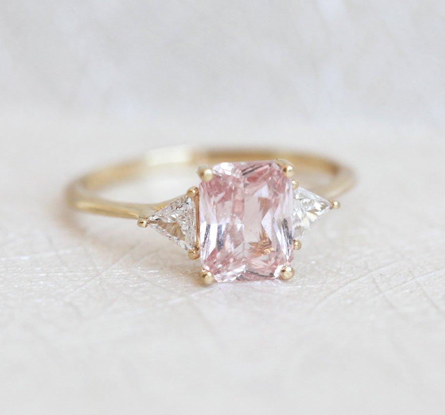 Radiant peach pink sapphire ring with white side diamonds