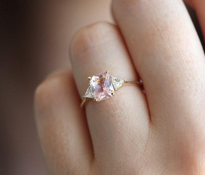 Radiant peach pink sapphire ring with white side diamonds