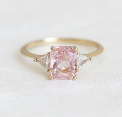 Radiant peach pink sapphire ring with white side diamonds