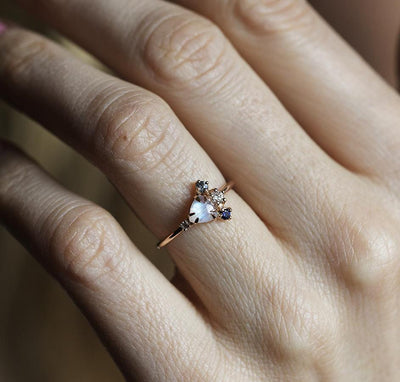 Trillion-cut white moonstone cluster ring with diamond and sapphire gemstones