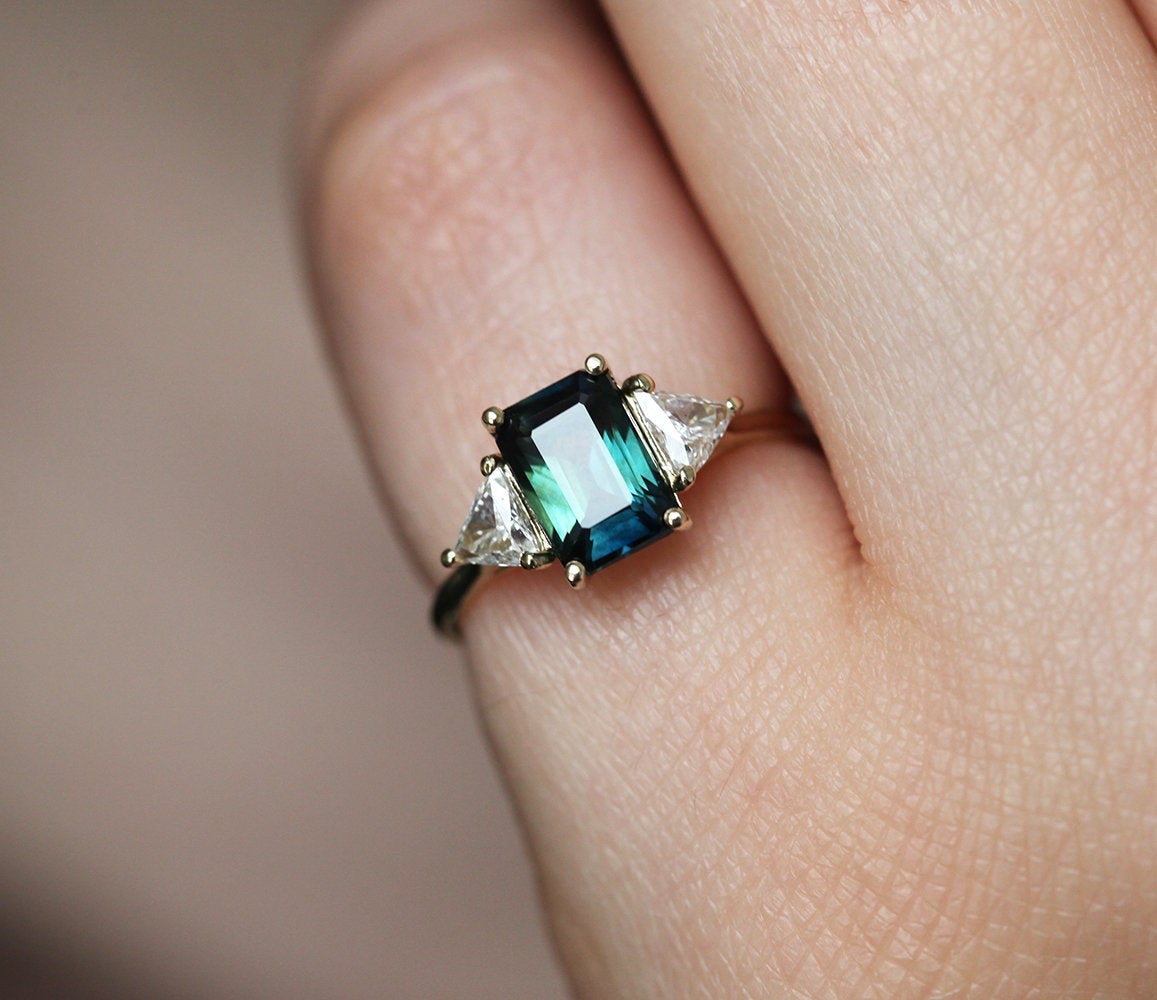 Emerald-cut teal sapphire ring with white diamonds