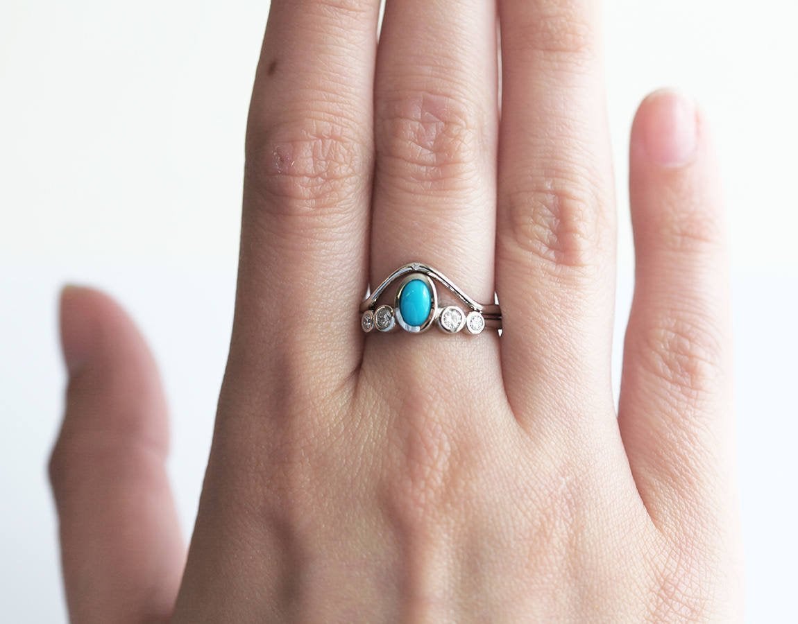 Oval-shaped blue turquoise and diamond cluster ring with curved band