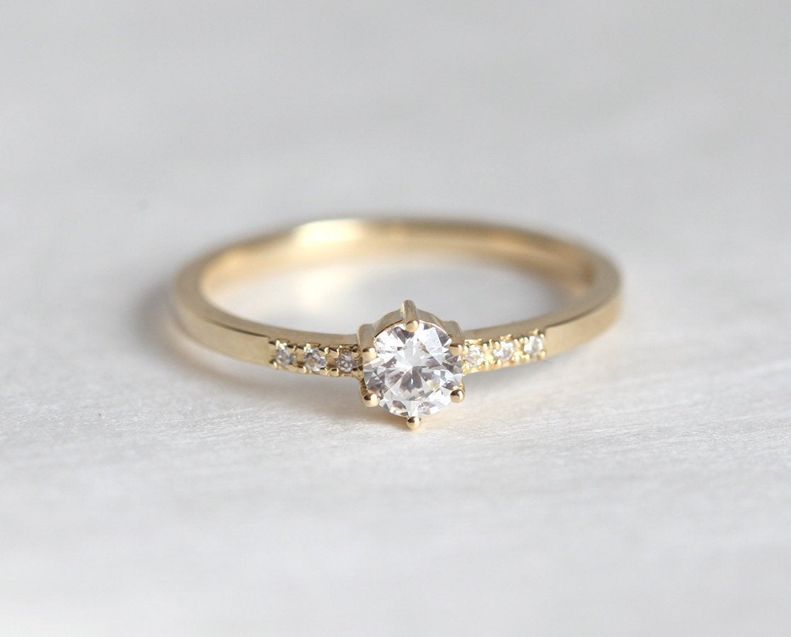 Round diamond engagement ring with side diamonds