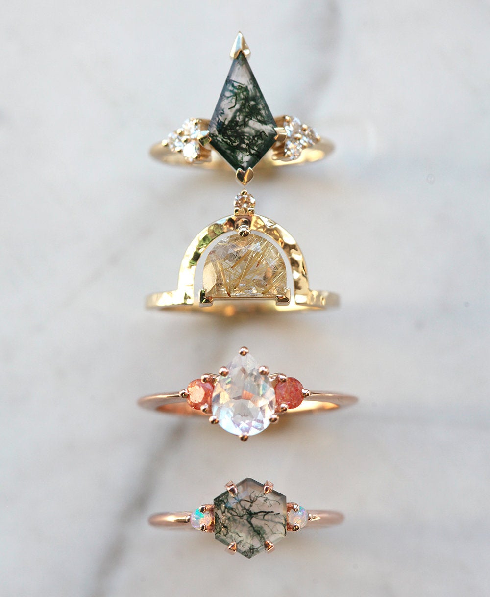Half-moon-shaped golden rutile quartz ring with champagne diamond and other rings