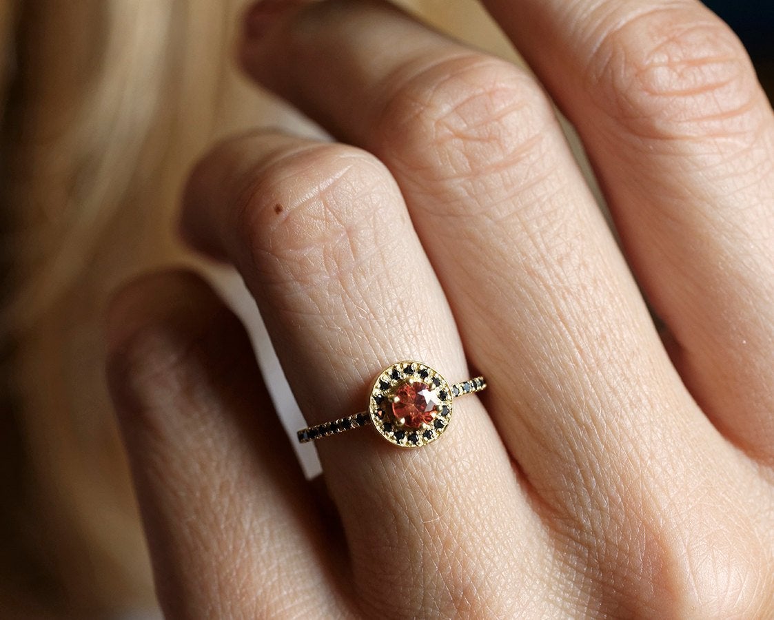Round orange sapphire eternity ring with black diamonds