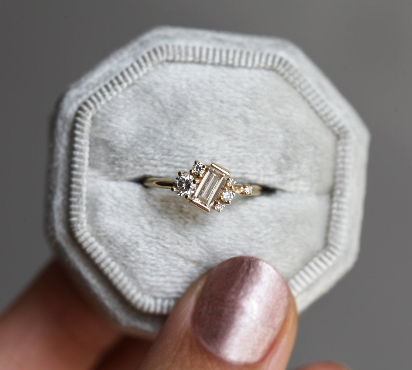 Baguette-shaped white diamond cluster ring with round white side diamonds