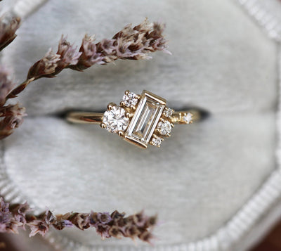 Baguette-shaped white diamond cluster ring with round white side diamonds