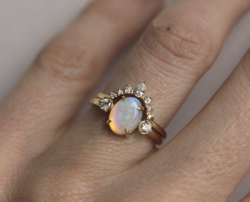 Nested pear-shaped white diamond crown ring and opal ring