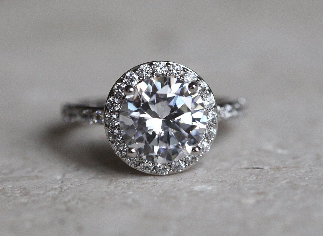 Round white moissanite engagement ring with diamond halo