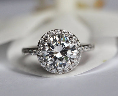Round white moissanite engagement ring with diamond halo