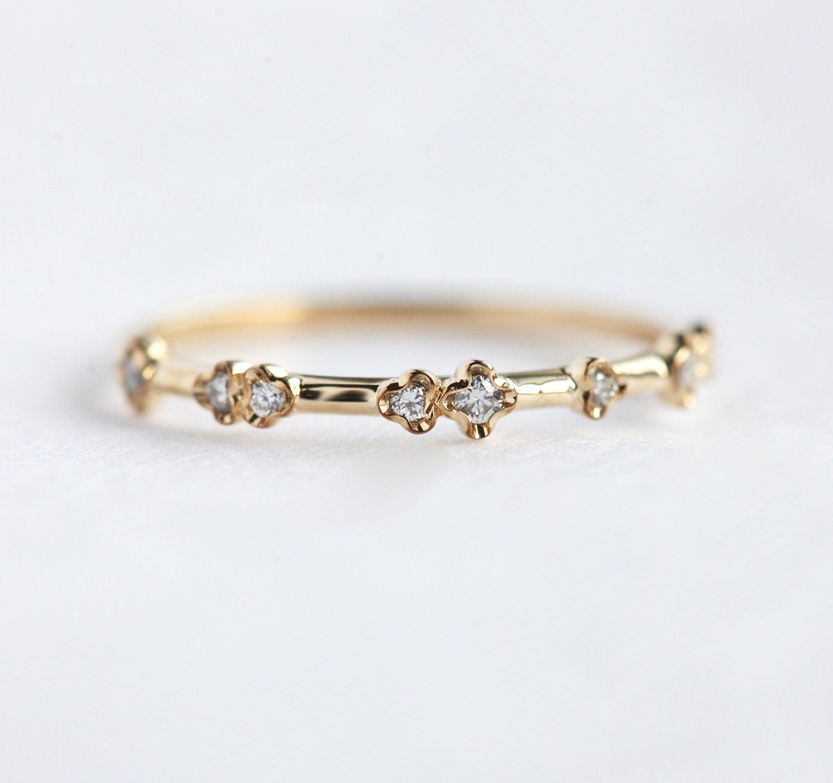 Elegant yellow gold diamond ring with a modern curved band design.