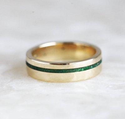 Close-up of Emerald Inlay Wedding Band, featuring crushed emerald inlay on 14k gold.