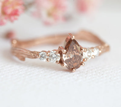 Pear-shaped peach champagne diamond ring with white side diamonds