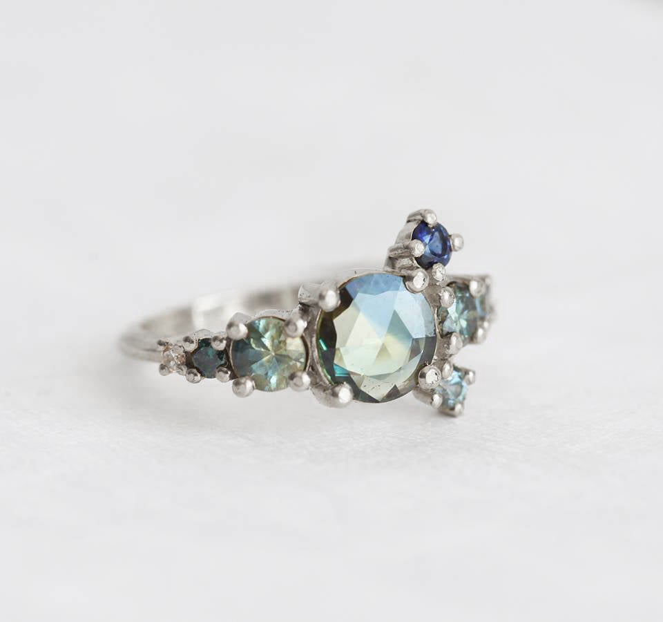 Round teal sapphire cluster ring with diamond and sapphire gemstones