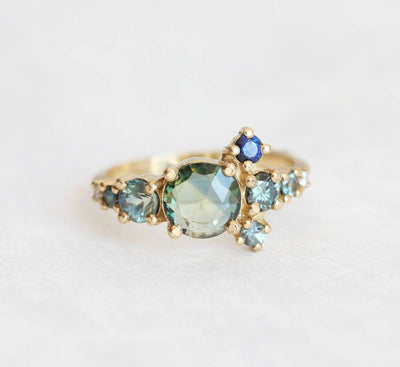 Round teal sapphire cluster ring with diamond and sapphire gemstones