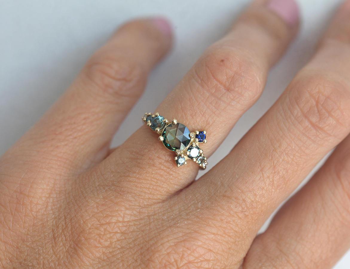 Round teal sapphire cluster ring with diamond and sapphire gemstones