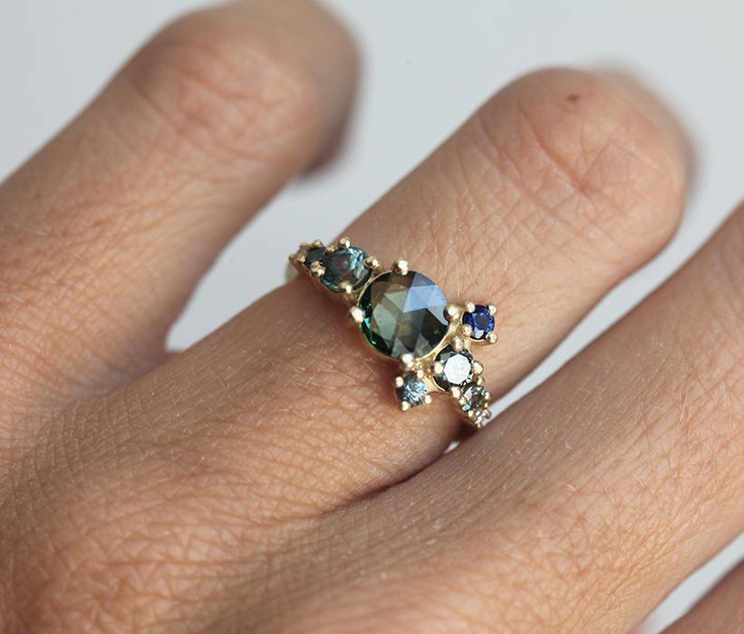 Round teal sapphire cluster ring with diamond and sapphire gemstones