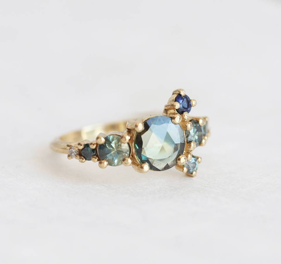 Round teal sapphire cluster ring with diamond and sapphire gemstones