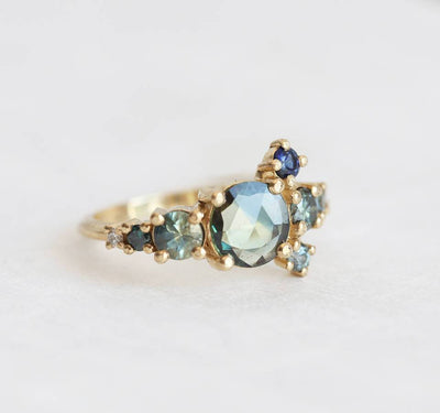 Round teal sapphire cluster ring with diamond and sapphire gemstones