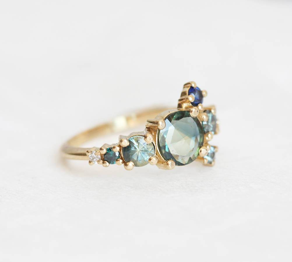 Round teal sapphire cluster ring with diamond and sapphire gemstones