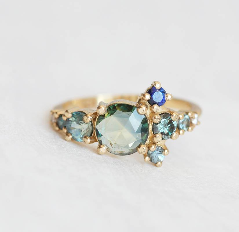 Round teal sapphire cluster ring with diamond and sapphire gemstones