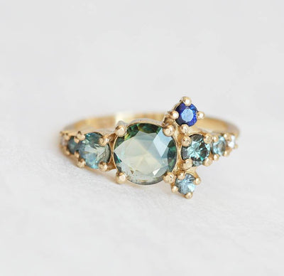 Round teal sapphire cluster ring with diamond and sapphire gemstones